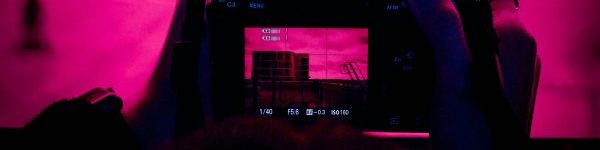 Home Person holding a camera, capturing a shot in low light