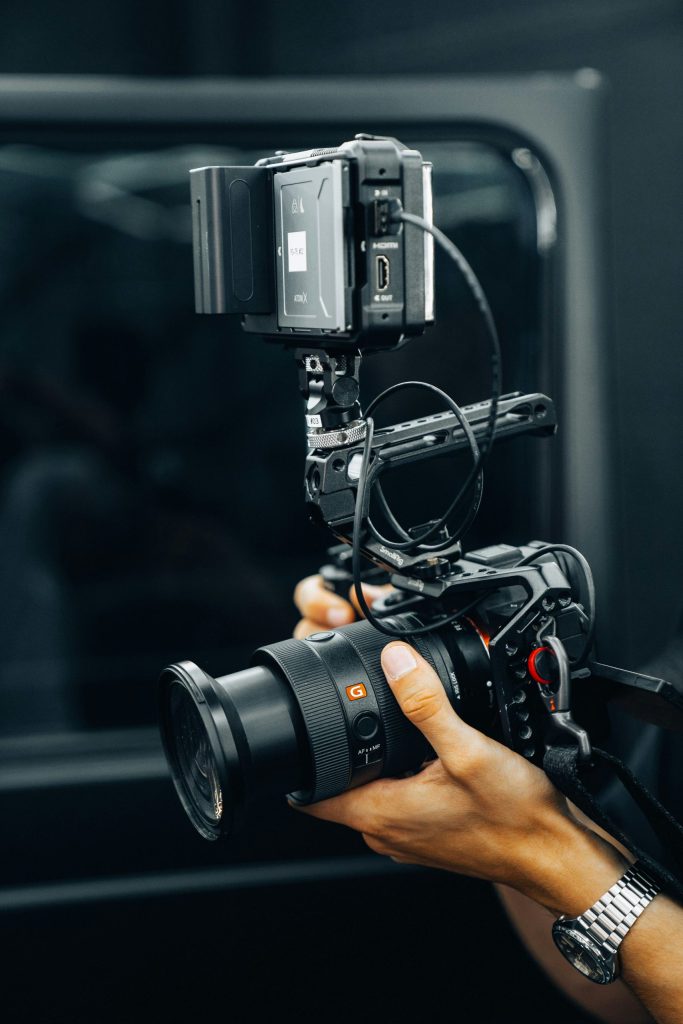 A person holding a video camera, focused and ready to capture the perfect shot—embodying creativity, storytelling, and the art of visual production.